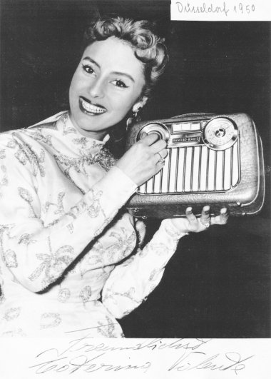 Caterina Valente mit einem Akkord-Radio. 